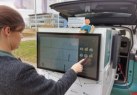 Lisa Rotfuß an einem der Demonstratoren des KI-Infomobils des Fraunhofer Instituts